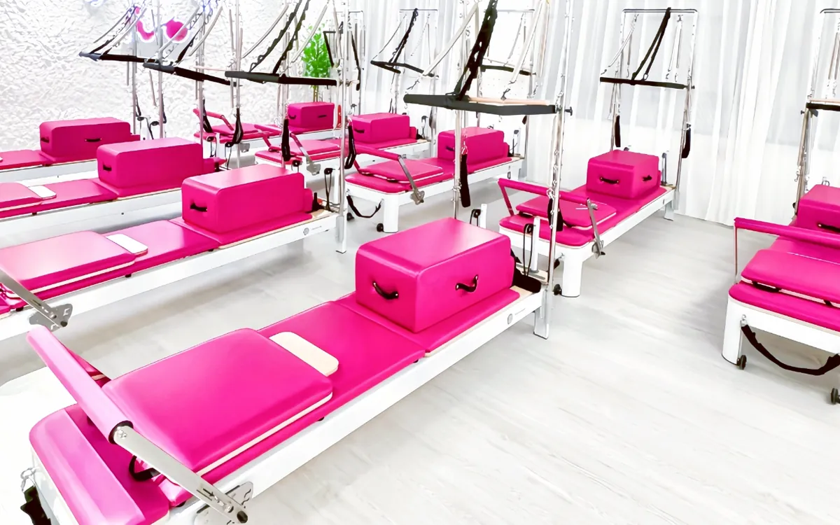 Bright pink reformers and towers at SG Pilates Bugis