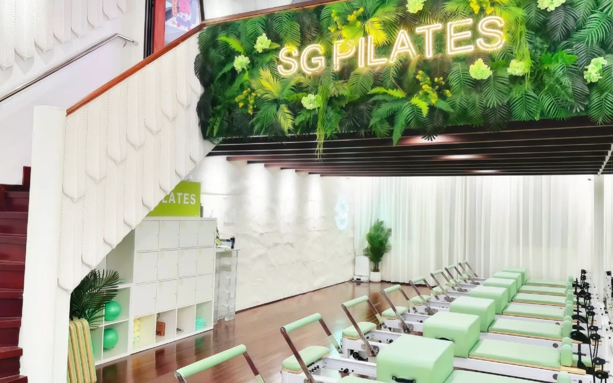 Green reformers below a living plant wall at SG Pilates Chinatown